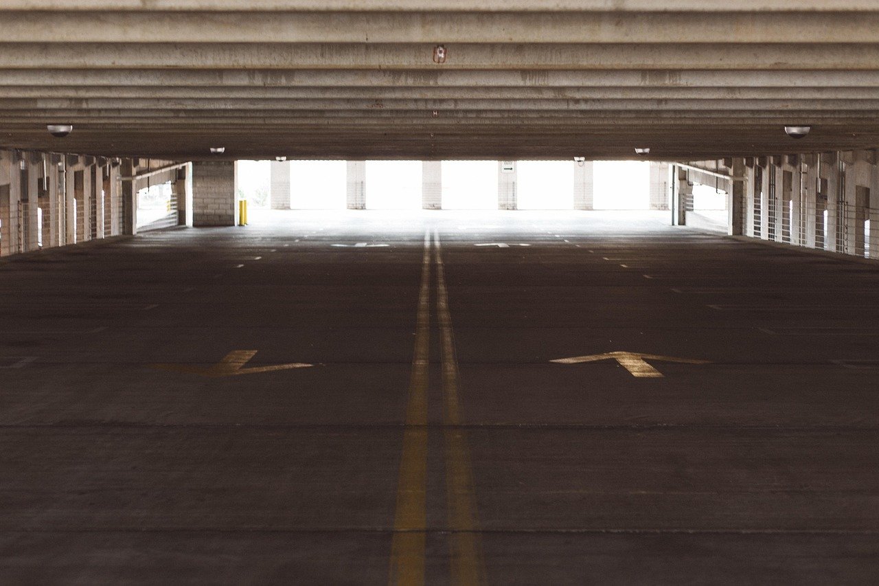 Estacionamiento y calle marrón, lotes de estacionamiento amplios y concurridos.