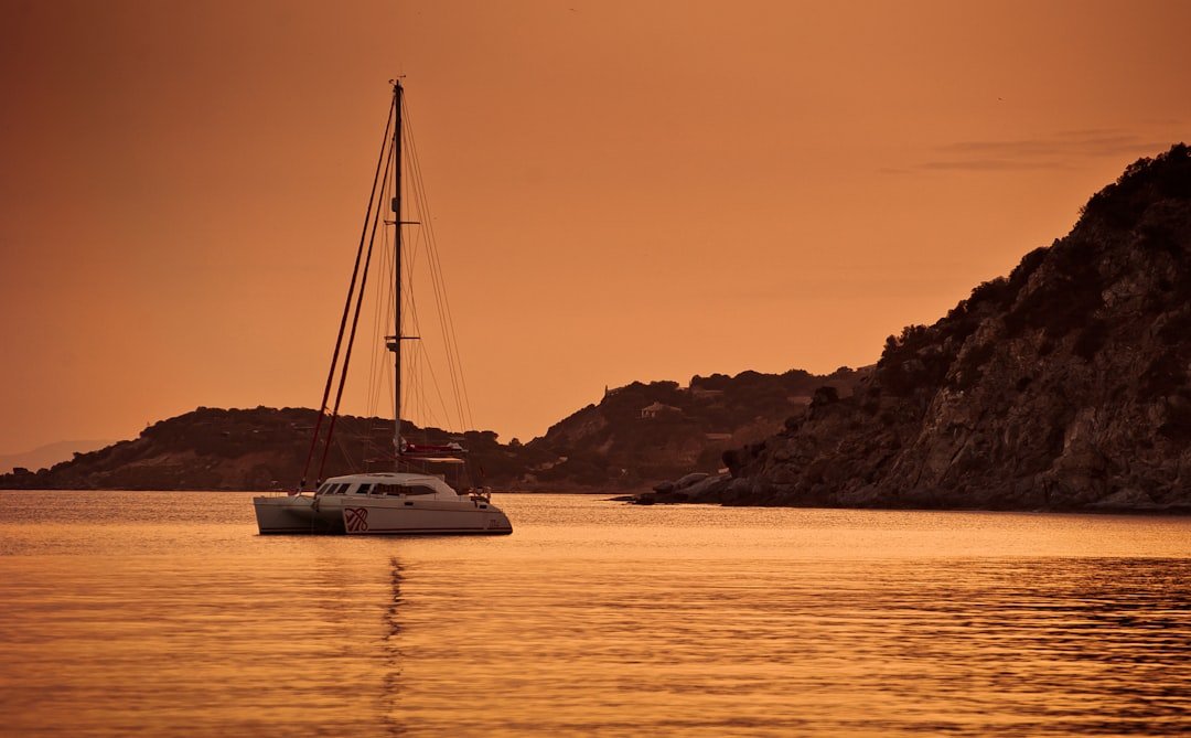 Catamarán blanco navegando al atardecer en Lloret de Mar.