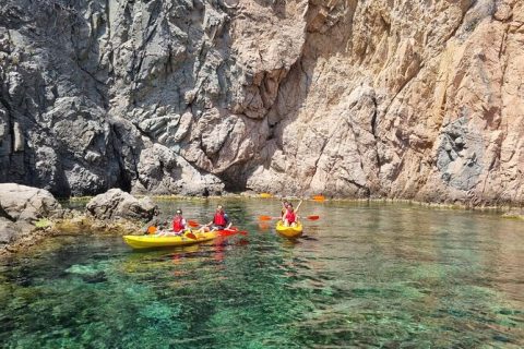 Persona haciendo kayak frente a la costa mediterránea