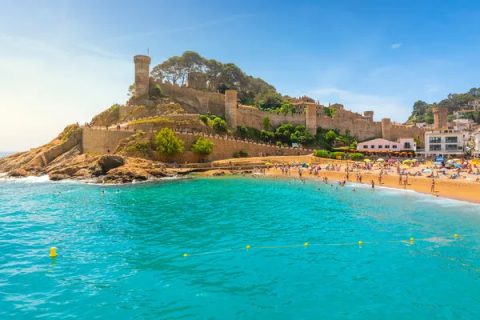Platja Gran de Tossa de Mar con la silueta medieval de la Vila Vella al fondo