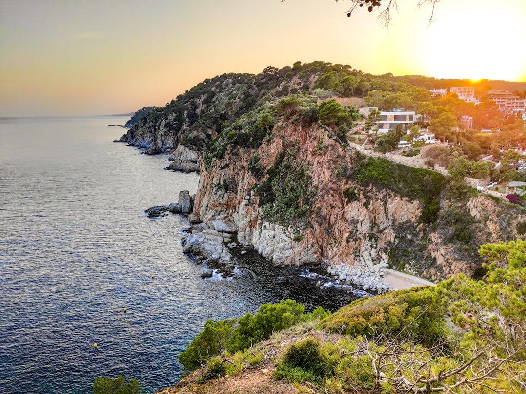 Familia feliz disfrutando un atardecer m&aacute;gico en la playa de Tossa de Mar, Costa Brava.