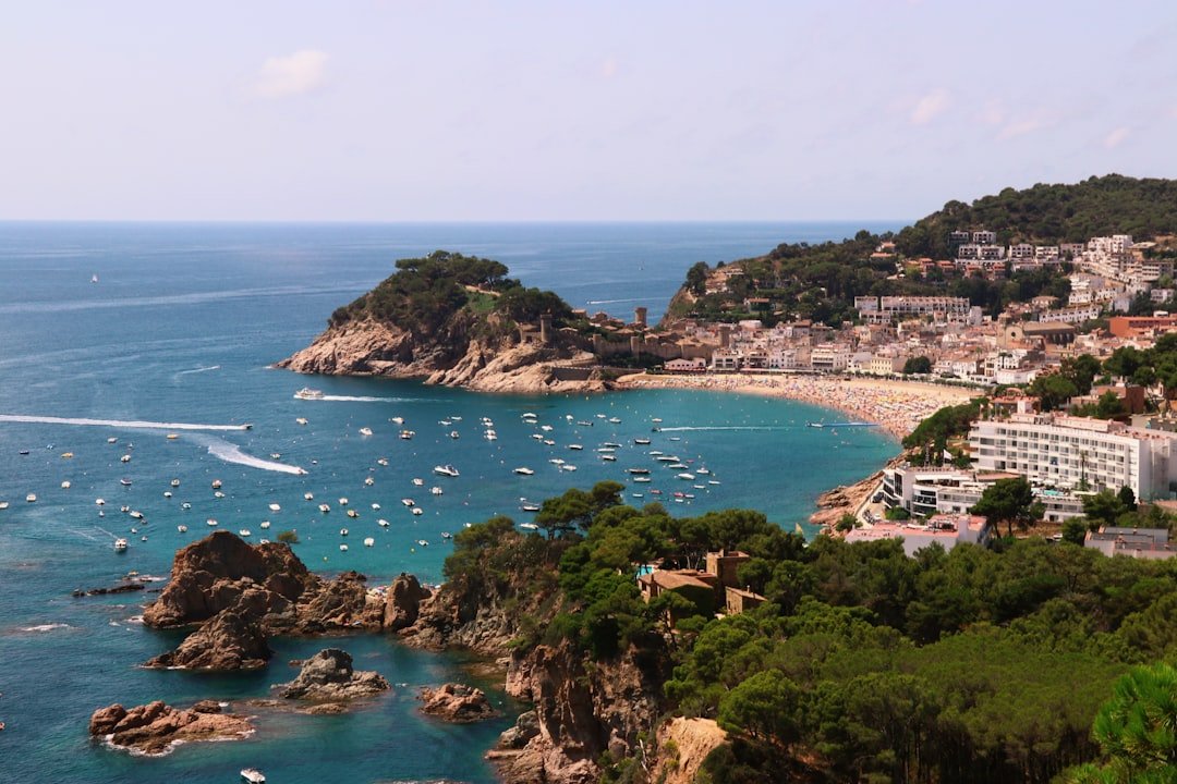 Vista panor&aacute;mica de la playa de Lloret con embarcaciones, ilustrando empresas de embarcadero y c&oacute;mo elegirlas.
